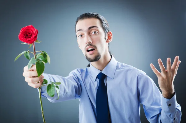 Mladý muž s červenou růží — Stock fotografie