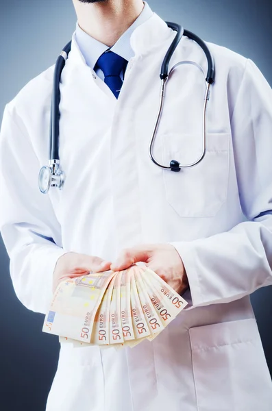 Doctor with money in studio — Stock Photo, Image