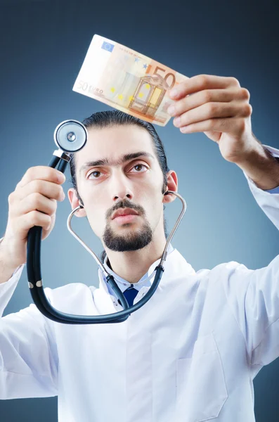 Doutor com dinheiro em estúdio — Fotografia de Stock