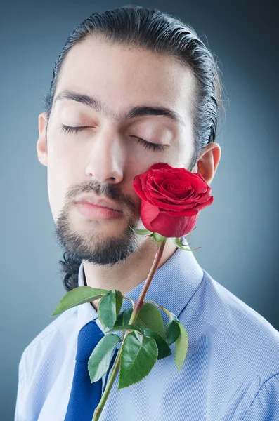 Junger Mann mit roter Rose — Stockfoto