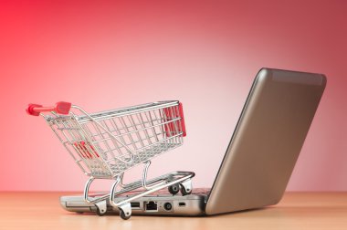 Internet online shopping concept with computer and cart clipart