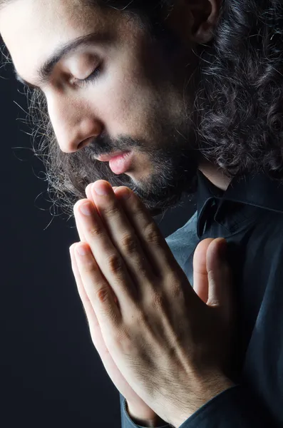 Giovane uomo che prega nelle tenebre — Foto Stock