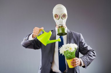 gaz maskesi ve çiçeklerle işadamı