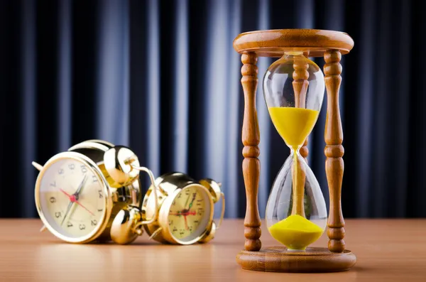 Time concept with alarm clock and hourglass — Stock Photo, Image