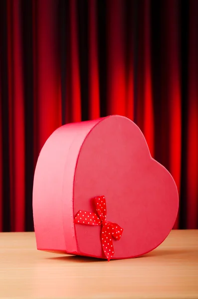 Dárková krabice proti pozadí ve tvaru srdce — Stock fotografie