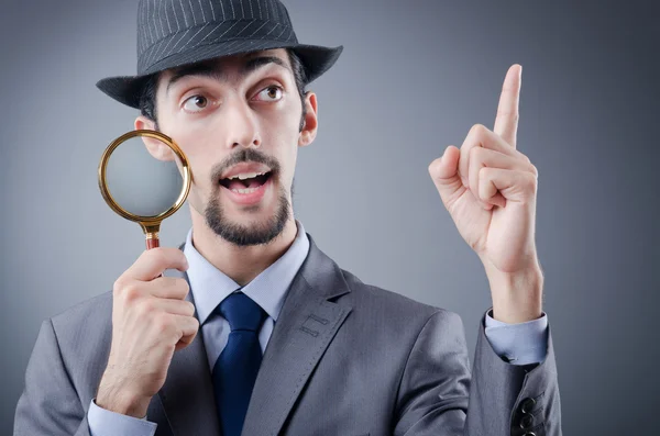 Detective and magnifying glass — Stock Photo, Image