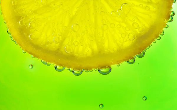 Primer plano de una rodaja de limón con burbujas — Foto de Stock