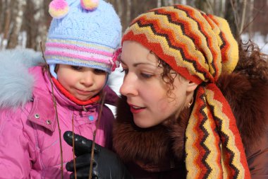 Mother and daughter in wood in winter closeup clipart