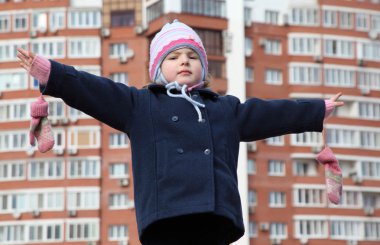 Little girl with divorced hands against background building clipart