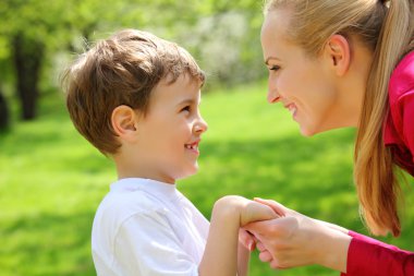 Mother and son look against each other having joined hands in pa clipart