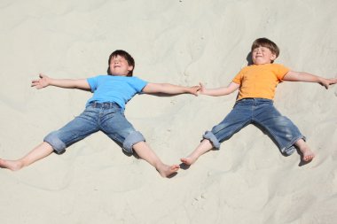 iki çocuk kum üzerine yakındaki yalan