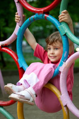 Girl hanging on rings clipart