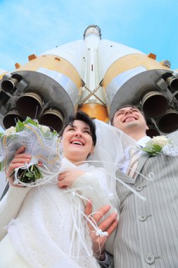 Space rocket over fiance and bride clipart