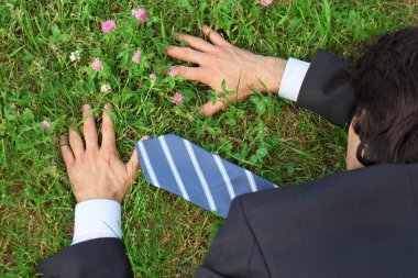 işadamı çimenlerin üzerinde üstten görünüm yüzükoyun yatıyor