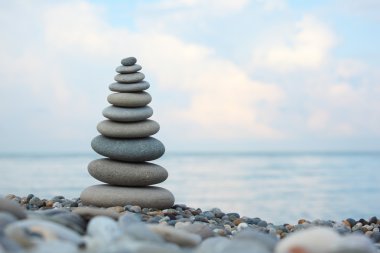 Stone stack on pebble beach clipart