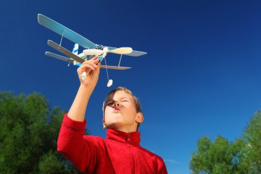çocuk ile gökyüzü karşı açık elinde oyuncak uçak