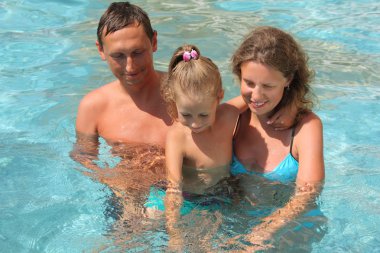 mutlu bir aile ile küçük kız havuzda oynuyor