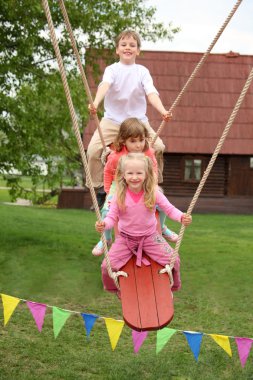 Three children on teetering-board clipart