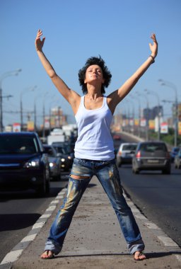 Girl stands on middle of road with rised hands clipart