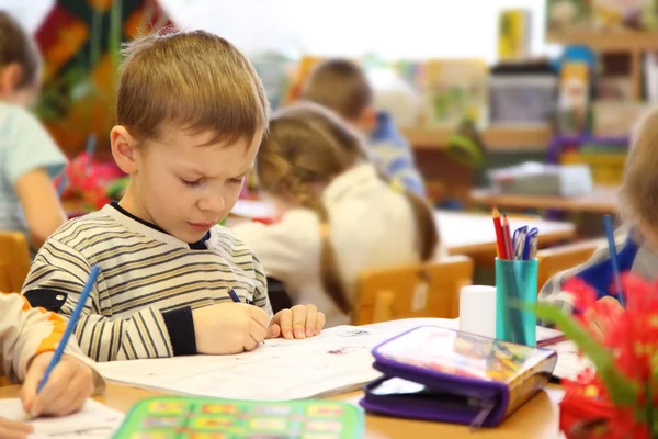 Chlapec kreslí ve školce — Stock fotografie