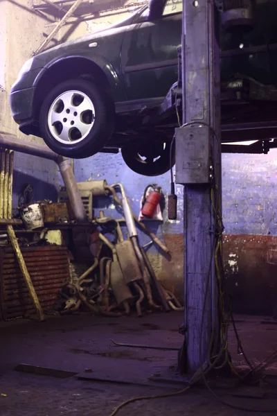 Car on lift in workshop — Stock Photo, Image