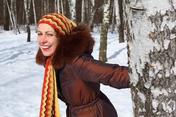 Young beautiful woman in wood keeps for birch in winter — Stock Photo, Image
