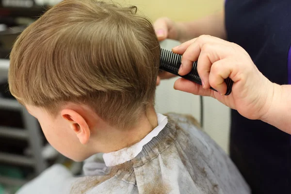Dreng skåret i frisørsalon - Stock-foto