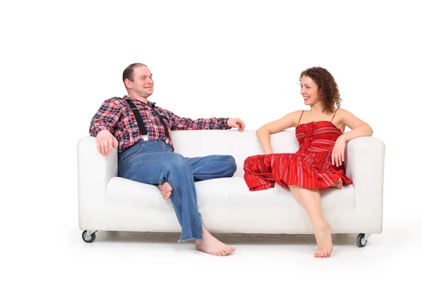 Bosý muž a žena sedí na bílé kožené pohovce — Stock fotografie