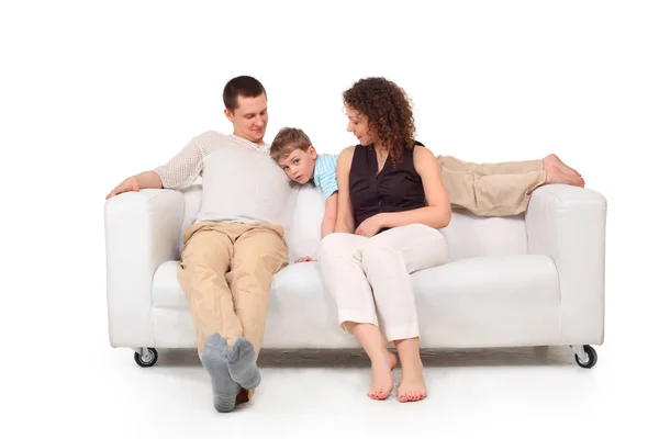 Pais com filho no sofá de couro branco — Fotografia de Stock