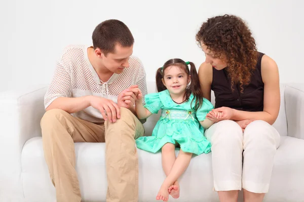 Ouders en dochter op witte lederen sofa — Stockfoto