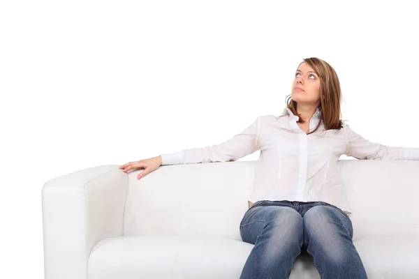 Fiatal szép, mezítláb nő ül a fehér bőr kanapé — Stock Fotó