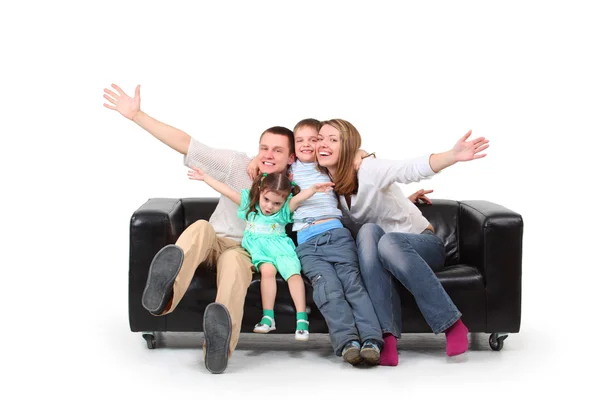 Família feliz no sofá de couro preto — Fotografia de Stock