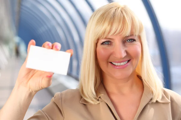 stock image Smiling middleaged businesswoman show card