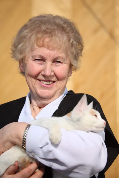 Улыбающаяся пожилая женщина с котом — стоковое фото