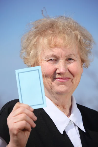 Mujer anciana sostiene la tarjeta en la mano — Foto de Stock