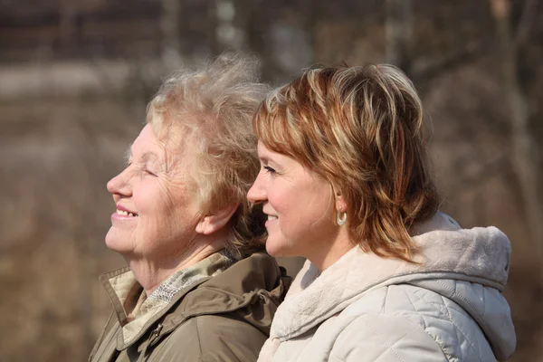 Smiling elderly woman and her daughter in profile — Stock Photo, Image