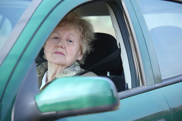 Äldre kvinna ser ut i bil — Stockfoto