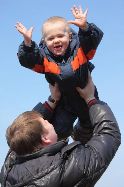 Child in sky on father's hands — Stock Photo, Image