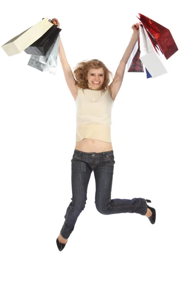 Šťastný tančících blondýnka drží papírové tašky v nevylezlo rukou — Stock fotografie