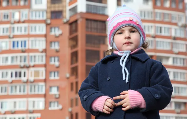 Маленькая девочка против нового здания — стоковое фото