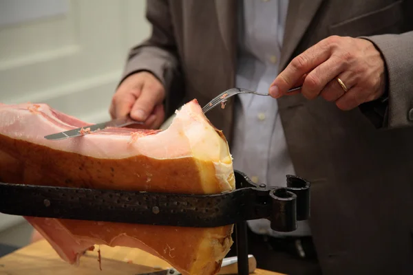Uomo taglia grosso pezzo di carne di maiale affumicata — Foto Stock