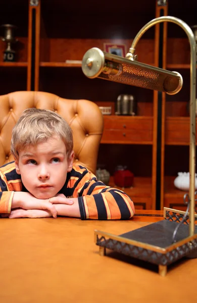 Мальчик сидит в роскошном офисе — стоковое фото