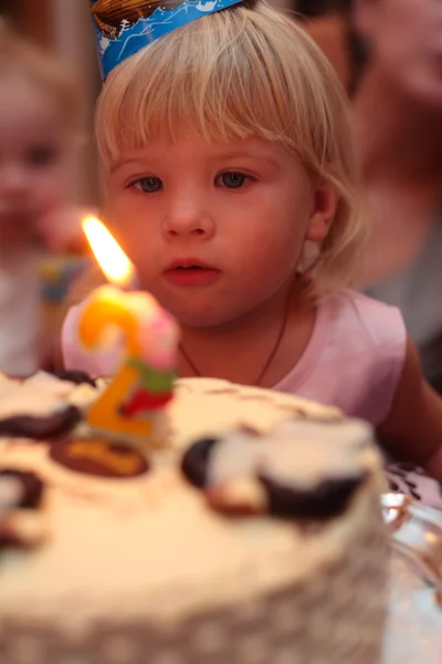 Little girl blowing on birthday cake — Stock Photo, Image