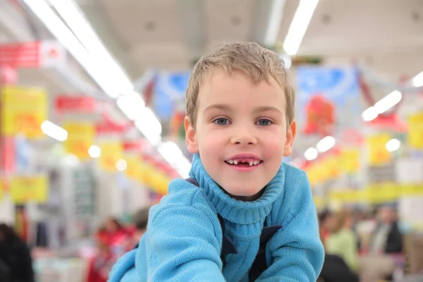 Boy without foreteeth in shop — Stock Photo, Image