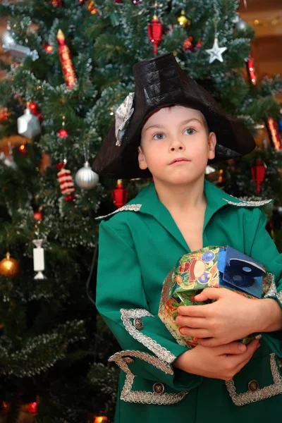 Мальчик на новогоднем маскараде в детском саду под елкой — стоковое фото
