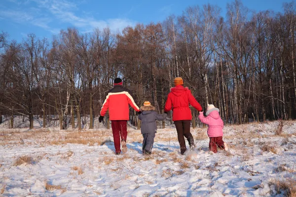 Семья бежит из дома в лес зимой — стоковое фото