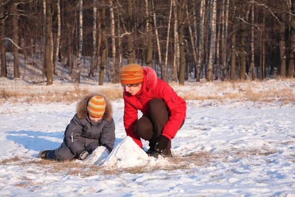 Mother plays with son in wood in winter — Stock Photo, Image