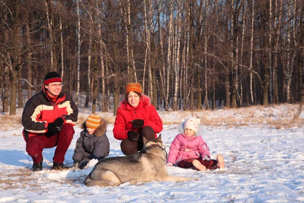 Eltern mit Kindern und Hund im Winter im Wald — Stockfoto