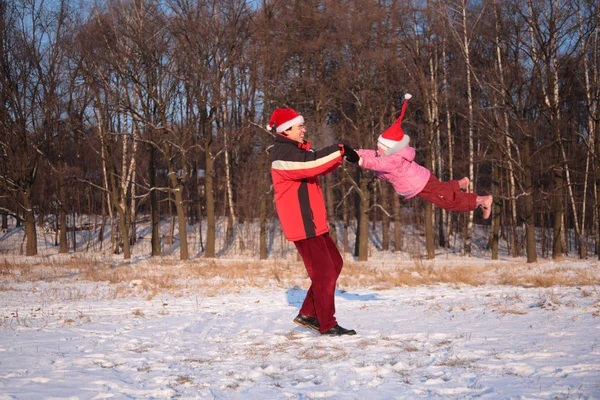 Vater lässt Tochter im Winter im Wald rotieren — Stockfoto