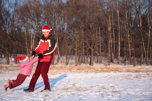 Pai girar filha em madeira no inverno — Fotografia de Stock